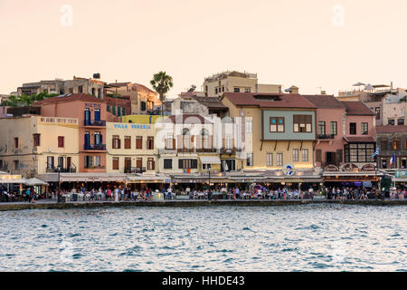 Sonnenuntergang über der Strandpromenade Restaurants am Wasser auf dem alten venezianischen Hafen von Chania, Kreta, Griechenland Stockfoto