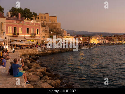 Sonnenuntergang über der Strandpromenade Restaurants am Wasser auf dem alten venezianischen Hafen von Chania, Kreta, Griechenland Stockfoto