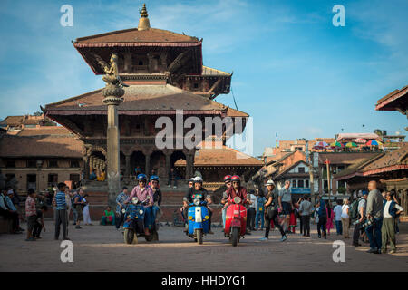 Eine Gruppe von Touristen sitzen mit ihren Rollern in der historischen Temple Square in Patan, Kathmandu, Nepal Stockfoto