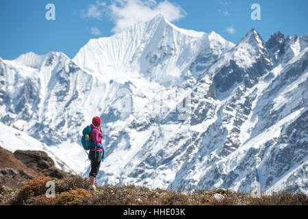 Eine Frau in das Langtang-Tal mit Blick auf Ganchempo in der Ferne, Langtang Region, Nepal trekking Stockfoto