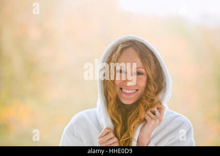 Porträt, lächelnde Frau tragen Kapuzen-Bademantel Stockfoto