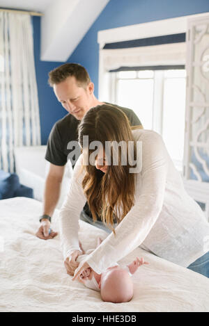 Zwei Eltern, Mutter und Vater auf dem Wickeltisch Windel des Babys ändern. Stockfoto