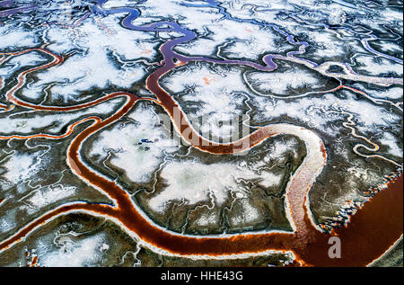 Blick auf die Landschaft, gewundene Wasserkanäle und die Salinen mit weißen Salz und mineralischen Ablagerungen am Alvisio. Stockfoto