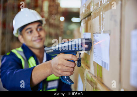 Arbeiter mit Scanner Scannen von Barcodes auf Box im Auslieferungslager Stockfoto