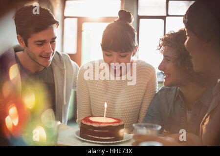 Jungen Erwachsenen Freunden feiert Geburtstag mit Kuchen und Kerzen Stockfoto