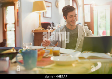 Junger Mann mit Laptop beim Frühstück studieren College-student Stockfoto