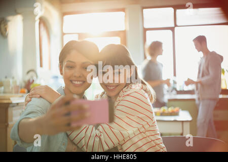 Junge Frauen Freunde Mitbewohner umarmt nehmen Selfie mit Kamera-Handy Stockfoto