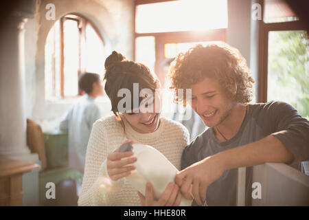 Junges Paar Mitbewohner Blick auf Ablaufdatum auf Milch in Küche Stockfoto