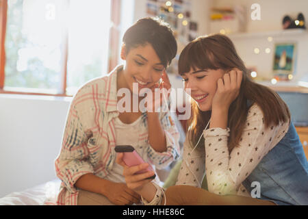 Junge Frauen Freunde teilen Kopfhörer Musik hören mit MP3-player Stockfoto