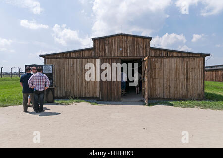 Besucher in einem der gut erhaltenen Holzhütten, die Frauen Schlafräume in 11 Auschwitz-Birkenau in Oswiecim in Polen Stockfoto