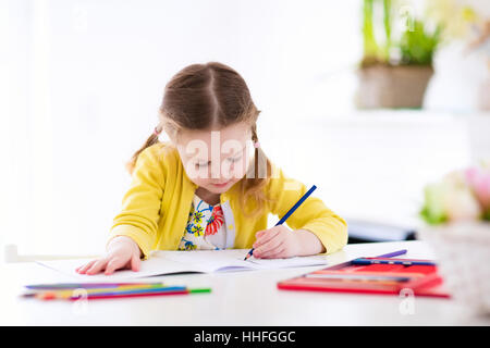 Niedliche kleine Mädchen Hausaufgaben machen, ein Buch zu lesen, Malvorlagen, schreiben und malen. Kinder malen. Kinder ziehen. Stockfoto