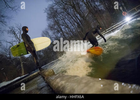 Eisbach River, Deutschland. 18. Januar 2017. Ein Mann surft auf die Welle mit seinem Surfbrett im Schnee und Temperaturen weit unter dem Gefrierpunkt am Eisbach River im englischen Garten der Nacht vom 18. bis 19. Januar 2017. Der Eisbach stehende Welle in der Prinzregenten-Strasse ist ein beliebter Ort bei Surfern das ganze Jahr über. Bildnachweis: Dpa picture Alliance/Alamy Live News Stockfoto