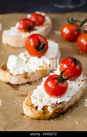 Bruschetta mit gerösteten Tomaten und frischem Ricotta-Käse, garniert mit Olivenöl extra vergine. Italienische Küche Vorspeise. Stockfoto