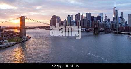 New York City Panorama Landschaft Szene bei Sonnenuntergang mit Brooklyn Bridge über den East River und Lower Manhattan Skyline von Wolkenkratzern Stockfoto