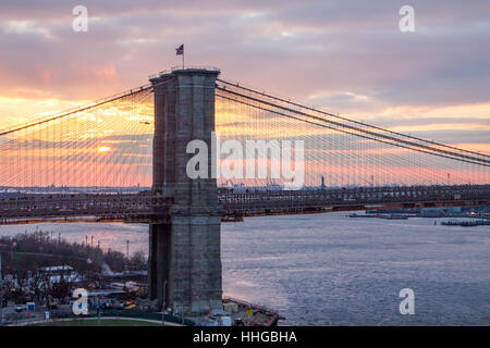 New York City farbenfrohen Sonnenuntergang Landschaft Szene mit der Brooklyn Bridge über den East River in Richtung Manhattan Stockfoto