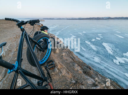 Fatbike auch als fat-Bike oder Fett-Reifen Fahrrad - Radfahren auf großen Reifen Räder. Radfahrer geht auf seinem Fahrrad auf dem zugefrorenen See. Stockfoto