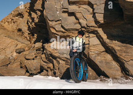 Fatbike auch als fat-Bike oder Fett-Reifen Fahrrad - Radfahren auf großen Reifen Räder. Radfahrer geht auf seinem Fahrrad auf dem zugefrorenen See. Stockfoto