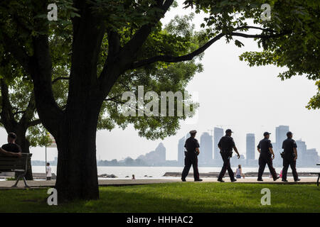 Vier Polizisten zu Fuß am Strand in Sunnyside Park, Toronto, Kanada Stockfoto