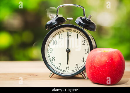 Retro-Uhr mit morgens Obst essen für die erste Mahlzeit-Konzept. Stockfoto