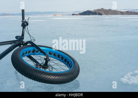 Fatbike auch fat-Bike oder Fett-Reifen Fahrrad genannt. Radfahren auf großen Rädern. Auf dem Eis liegen. Blick auf die Berge. Stockfoto