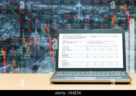 Laptop mit Investitionen Bildschirm auf Tisch mit Börse Markt Geschäft Handel mit Graph. Marketing Handel Geschäftskonzept. Stockfoto