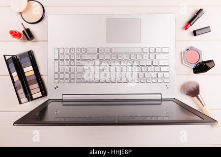 Arbeitsplatz für Fashion-Bloggerin, Laptop und Kosmetik auf dem Tisch Stockfoto