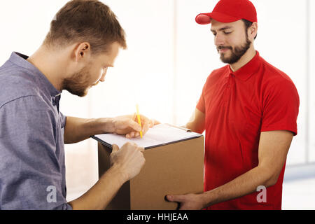 Lieferservice - Mann Unterzeichnung Übermittlungsbestätigung Box Stockfoto