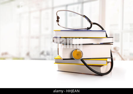 medizinische Ausbildung - Stapel Bücher mit Stethoskop auf dem Tisch in der Bibliothek Stockfoto