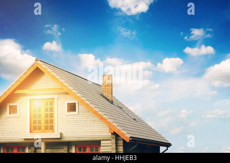 Log-Lodge mit grauen Ziegeldach gegen blauen Himmel Stockfoto