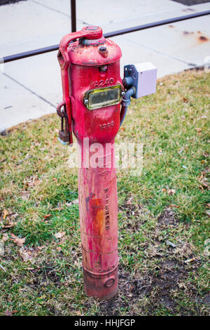 Eine alte helle rote EVU-Zähler in der Nähe von einem Bürgersteig Anzeichen von Verschleiß Stockfoto