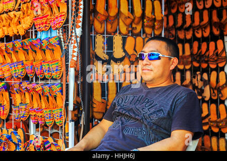 Mann verkauft handgemachte Lederschuhe auf einem Straßenmarkt auf der 5th Avenue, Riviera Maya, Playa Del Carmen, Mexiko Stockfoto