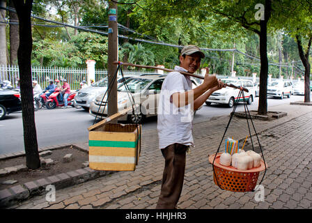 Kokos-Verkäufer zu Fuß auf einer Straße in Saigon, Vietnam. Stockfoto