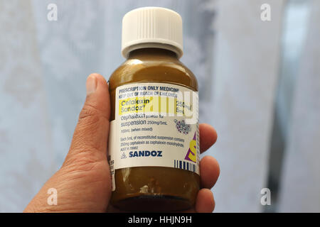 Hand hält Cefalexin Sandoz Antibiotikum Stockfoto