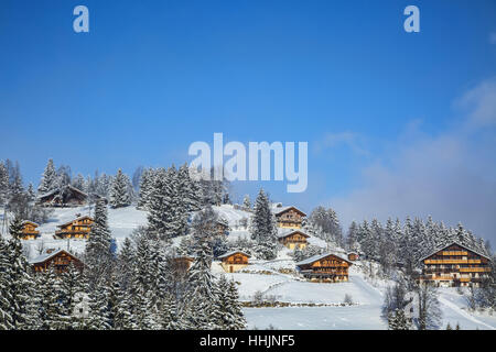 Bild von einer Höhenlage Holzchalets, die schneebedeckten Alpen. Stockfoto