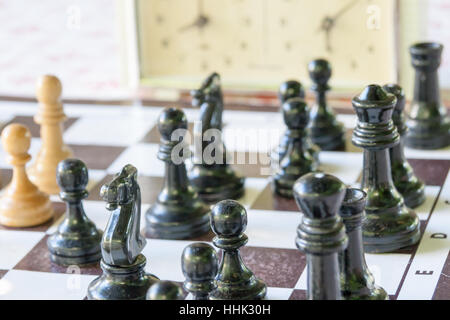 Schachfiguren und Stunden auf einer Tafel im klaren Sommertag Stockfoto