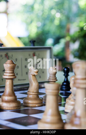 Schachfiguren und Stunden auf einer Tafel im klaren Sommertag Stockfoto