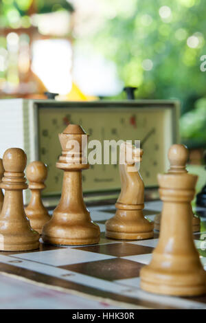 Schachfiguren und Stunden auf einer Tafel im klaren Sommertag Stockfoto