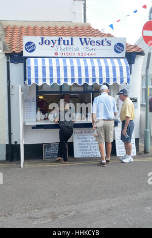 Kunden, die Schlange für die Lebensmittel vor freudiger West Schalentiere Bar in Sheringham, Norfolk, England Stockfoto