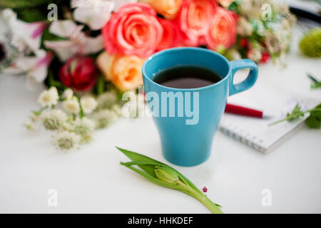 Tasse Tee auf dem Tisch, entspannen. Workshop-Florist, Tisch mit Blumen, Stillleben. Soft-Fokus Stockfoto