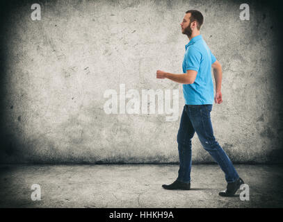 voller Länge Porträt des Gehens bärtiger Mann. Grunge städtischen Hintergrund Stockfoto