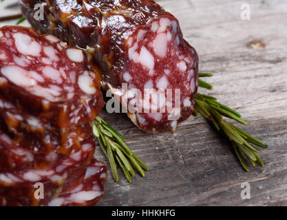 Scheiben der trockene Salami und Thymian auf Holztisch Stockfoto