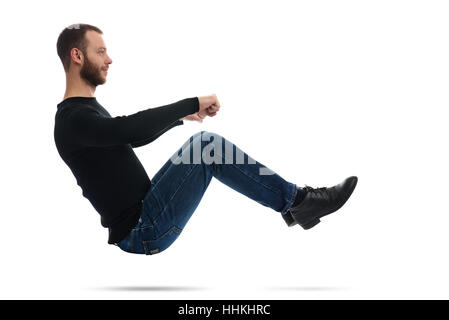 Profilbildnis einer jungen bärtigen Mannes hält ein virtuelles Lenkrad sitzt auf einem imaginären Auto. isoliert auf weißem Hintergrund Stockfoto