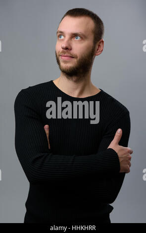 schöner bärtigen Mann blickte. Grauer Hintergrund Stockfoto