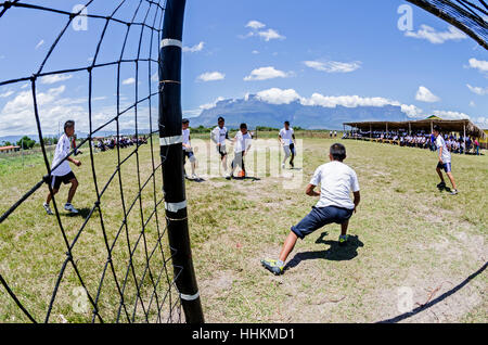 Einige Schüler aus der Schule Kamarata, befindet sich im Nationalpark Canaima Venezuela spielen ein Fußballspiel in ihrem Sport mit Hinterg Stockfoto