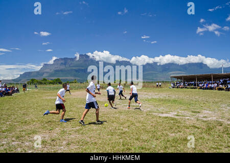 Einige Schüler aus der Schule Kamarata, befindet sich im Nationalpark Canaima Venezuela spielen ein Fußballspiel in ihrem Sport mit Hinterg Stockfoto