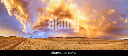 "Regenbogen im Paradies." Panorama-Foto von einem Regenbogen bei Sonnenuntergang nach einem schweren Gewitter auf dem Weg zum Baikalsee. Schönen Himmel bedeckt mit einem vari Stockfoto