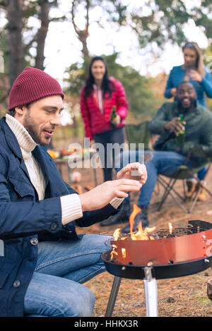 Mann Feuer am Grill anzünden Stockfoto