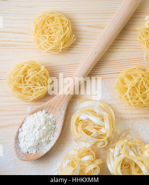 Vorbereitung der traditionellen italienischen hausgemachten Tagliatelle Nudeln mit Mehl und Ei auf einem Holztisch Stockfoto