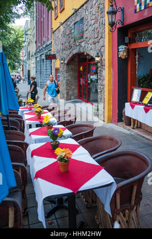 Outdoor-Bürgersteig entlang schöne Restaurants Bäumen gesäumte Hauptstraße in der Innenstadt von Greenville, South Carolina, USA. Stockfoto