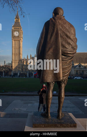 Das Denkmal für indische Führer Mahatma Gandhi mit den britischen Houses of Parliament im Hintergrund, am 18. Januar 2017, Parliament Square, London England. Mohandas Karamchand Gandhi war der überragende Führer der indischen Unabhängigkeitsbewegung im britisch beherrschten Indien. Stockfoto